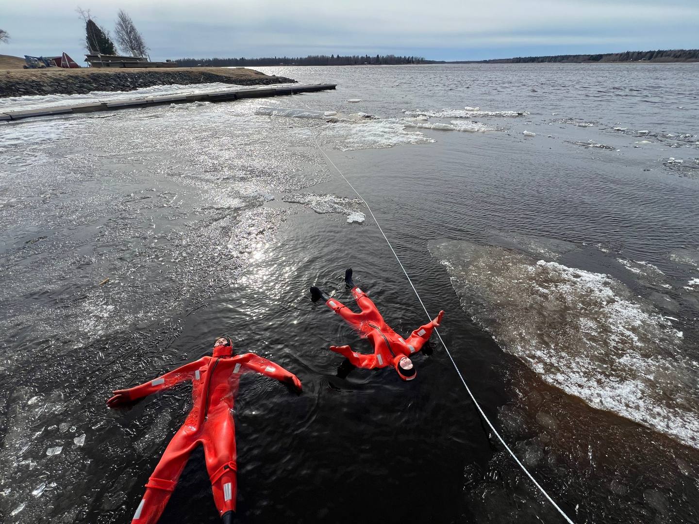 Deux personnes en combinaisons de flottaison parmi la banquise